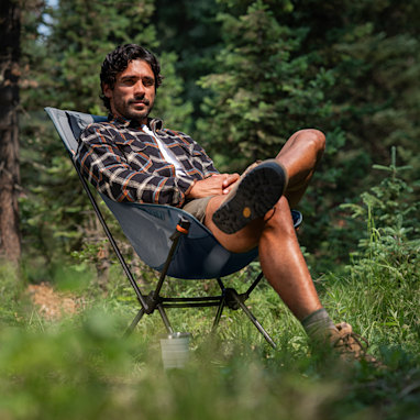Person relaxing in a hammock-style chair outdoors